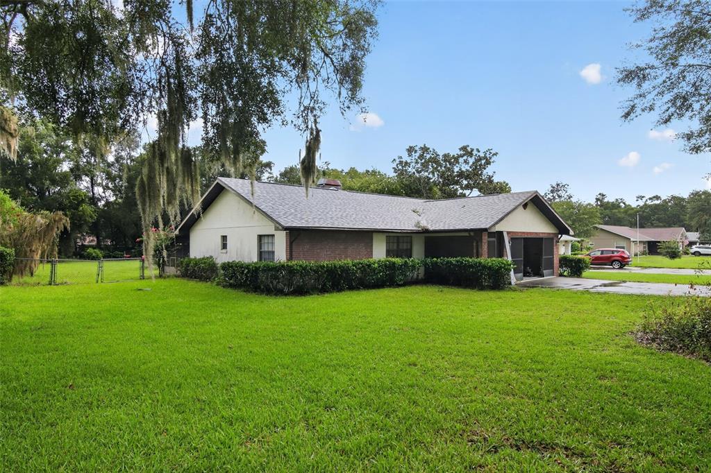 A single-story house with a brick and stucco exterior sits on a large grassy lawn — 4279 E ARLINGTON STREET, INVERNESS, FL