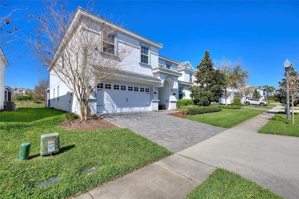 A two-story white house with a paved driveway and a two-car garage — 1524 FLANGE DRIVE, DAVENPORT, FL