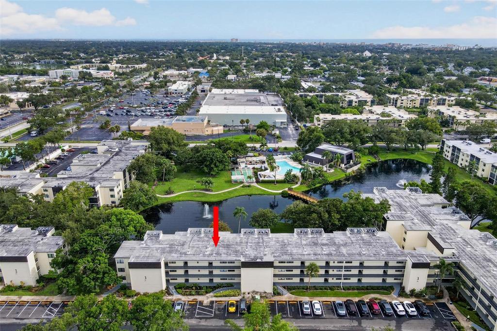 An aerial view shows a multi-story apartment building with a flat roof and parking lot — 14130 ROSEMARY LANE UNIT 3311, LARGO, FL