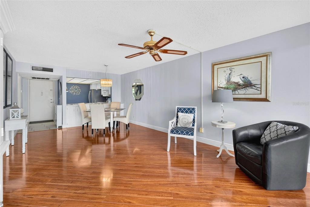 A living and dining area features hardwood floors, a ceiling fan, and light gray walls — 14130 ROSEMARY LANE UNIT 3311, LARGO, FL