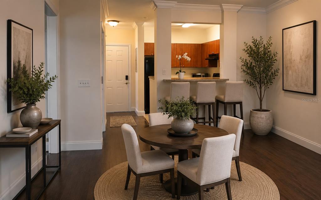 A dining area with a round table and chairs sits adjacent to a kitchen counter — 204 E SOUTH STREET UNIT 3060, ORLANDO, FL