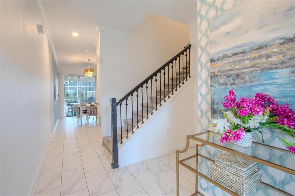 A foyer with white tile floors leads to a staircase and a dining area beyond — 962 SPLASH SHOT PLACE, DAVENPORT, FL
