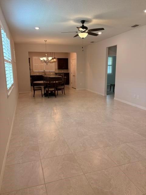 An open-concept dining area features tile flooring, a ceiling fan, and a kitchen in back — 9648 SW 63rd Loop, Ocala FL 34481, OCALA, FL
