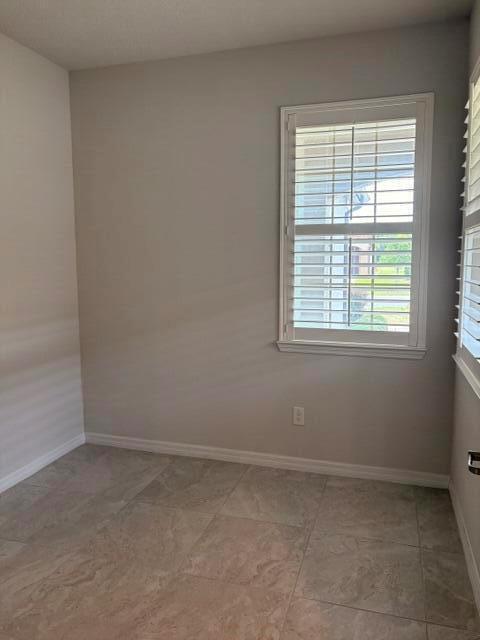 A room with light gray walls, tile flooring, and a window with white plantation shutters — 9648 SW 63rd Loop, Ocala FL 34481, OCALA, FL