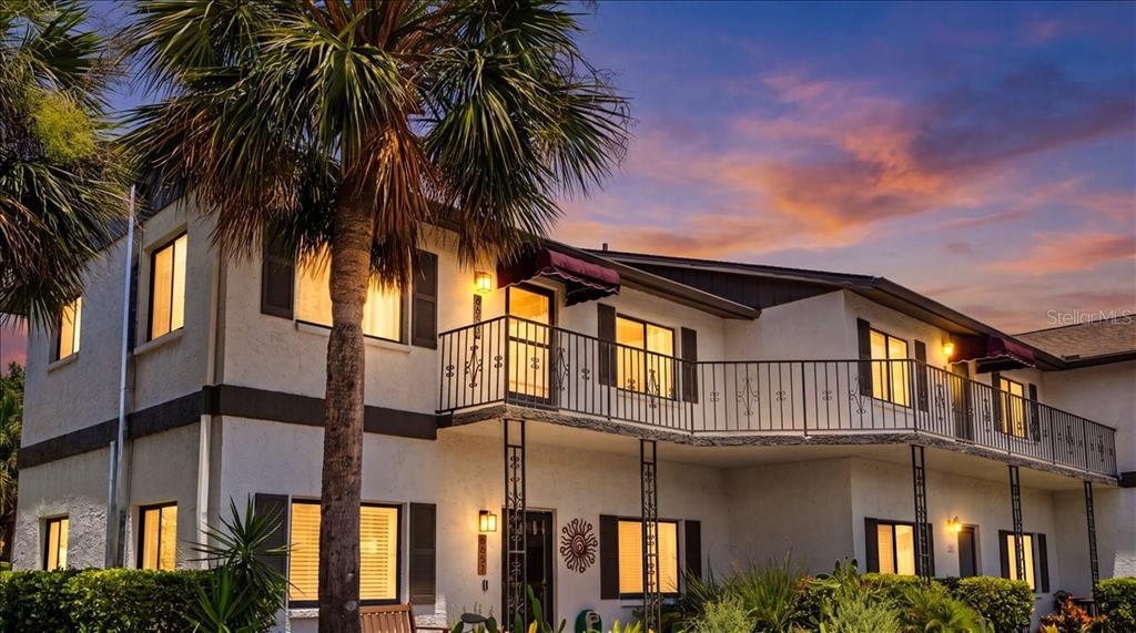 A two-story apartment building features a balcony with black railings and a palm tree — 6653 RIVER RUN BOULEVARD UNIT 6653, WEEKI WACHEE, FL