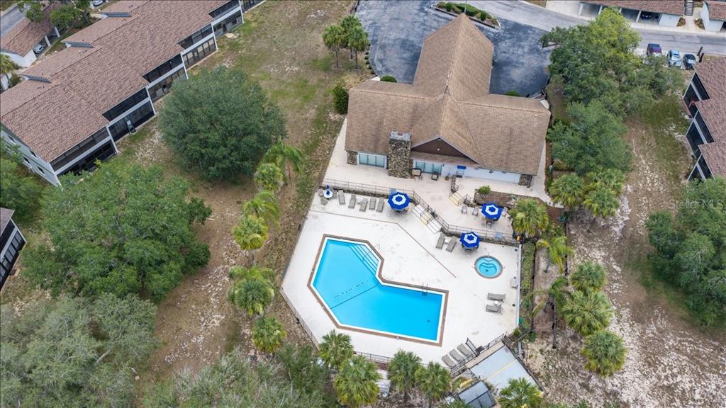 An aerial view shows a community clubhouse with a swimming pool and hot tub — 6653 RIVER RUN BOULEVARD UNIT 6653, WEEKI WACHEE, FL