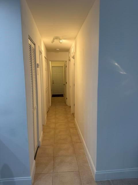 A narrow hallway with light-colored walls, tiled flooring, and several closed doors — 4357 NW 6 Avenue, Deerfield Beach FL 33064, DEERFIELD BEACH, FL