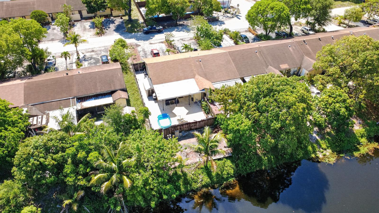 An aerial view shows townhomes with back patios, a small pool, and a canal — 4357 NW 6 Avenue, Deerfield Beach FL 33064, DEERFIELD BEACH, FL