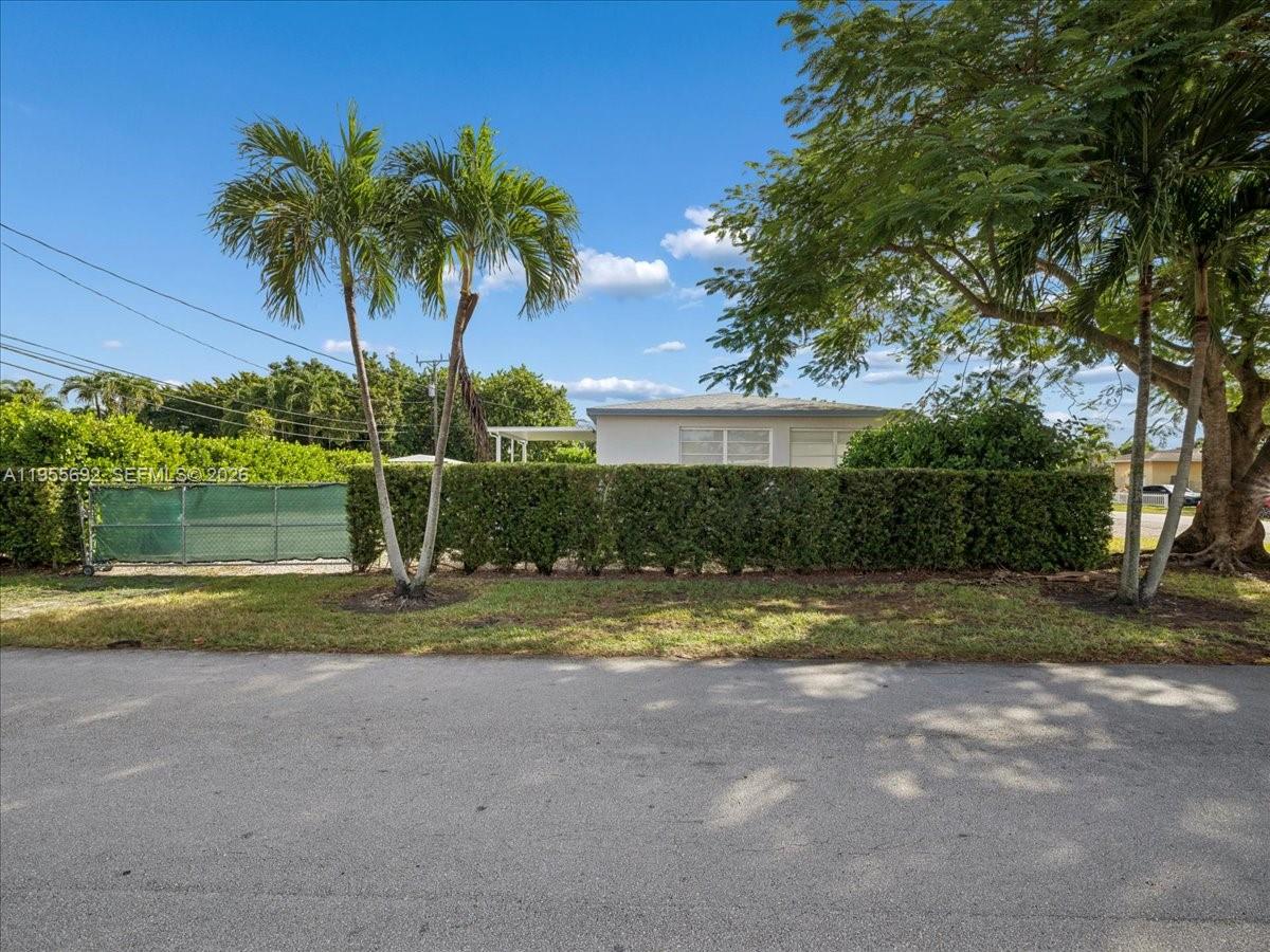 A single-story house sits behind a tall green hedge and two palm trees — 6891 SW 26th Ter, Miami FL 33155, MIAMI, FL