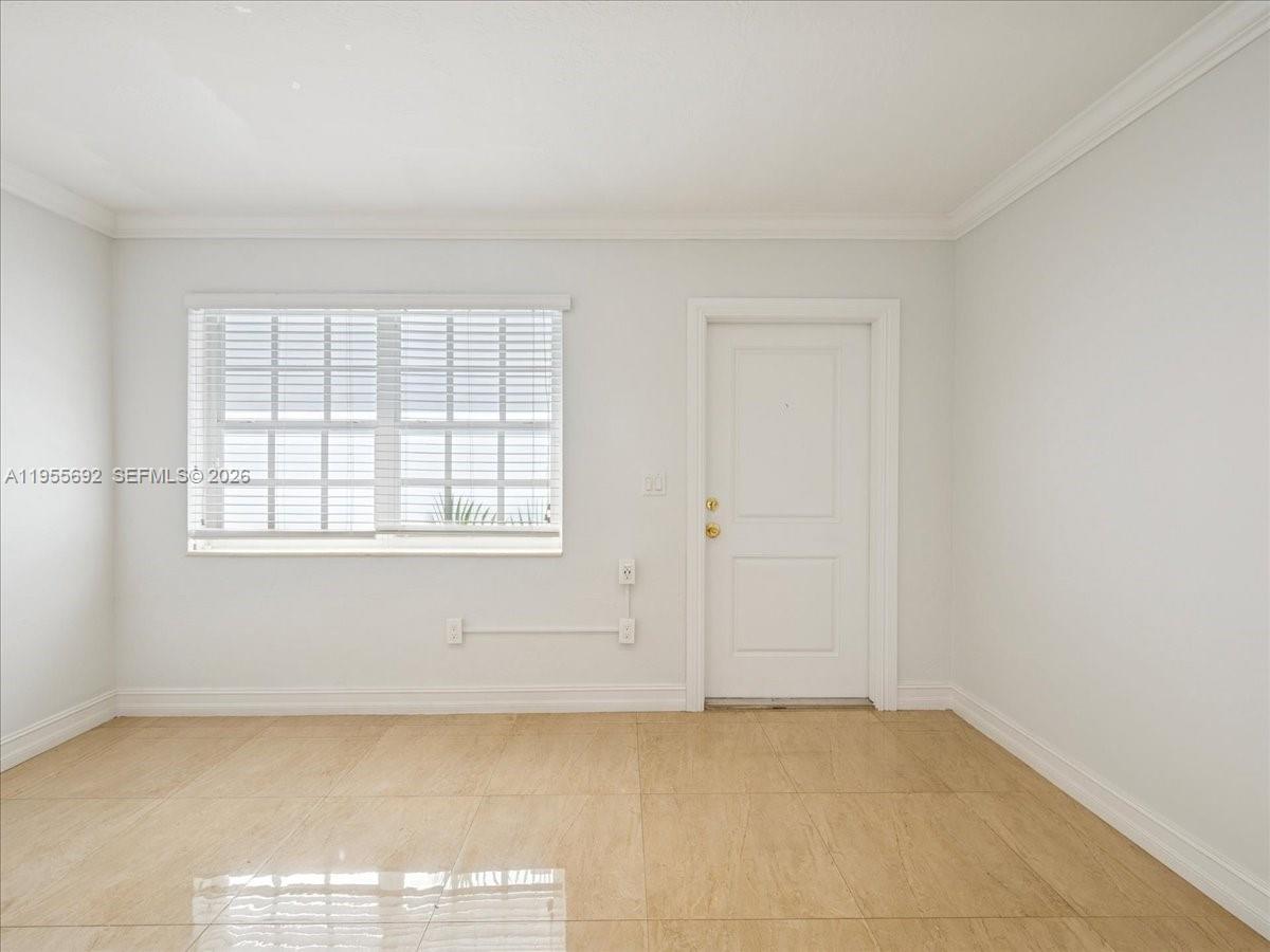 An empty room features light-colored tile flooring, a window with white blinds, and a door — 6891 SW 26th Ter, Miami FL 33155, MIAMI, FL