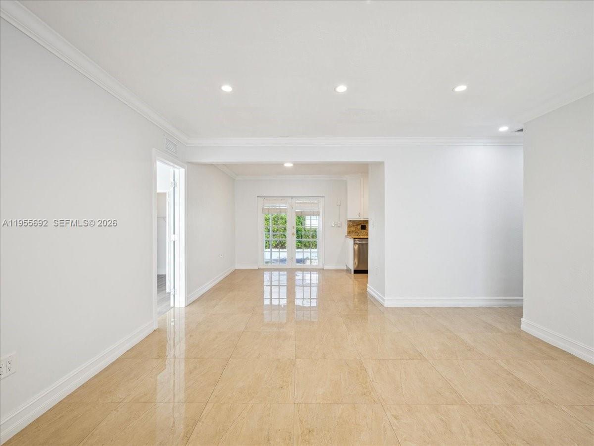 An empty room features light-colored tile flooring, white walls, recessed lighting, and glass patio doors — 6891 SW 26th Ter, Miami FL 33155, MIAMI, FL