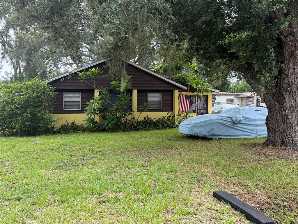 A sunroom features a ceiling fan, a box fan, a rug, and double glass doors — 6115 CLIFF AVENUE, GIBSONTON, FL