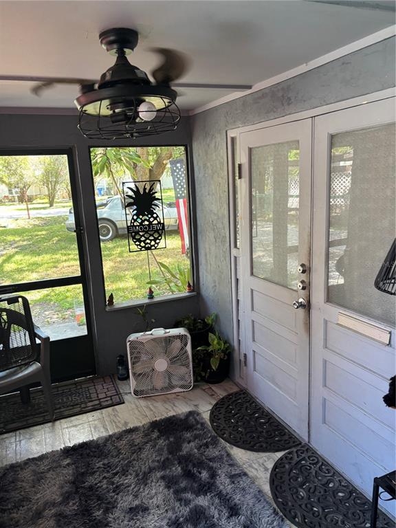 A living room features a large gray sectional sofa, a patterned area rug, and tile flooring — 6115 CLIFF AVENUE, GIBSONTON, FL