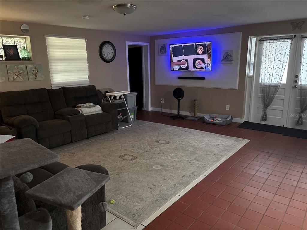 A kitchen features gray cabinets, white countertops, a geometric rug, and a cat on the floor — 6115 CLIFF AVENUE, GIBSONTON, FL