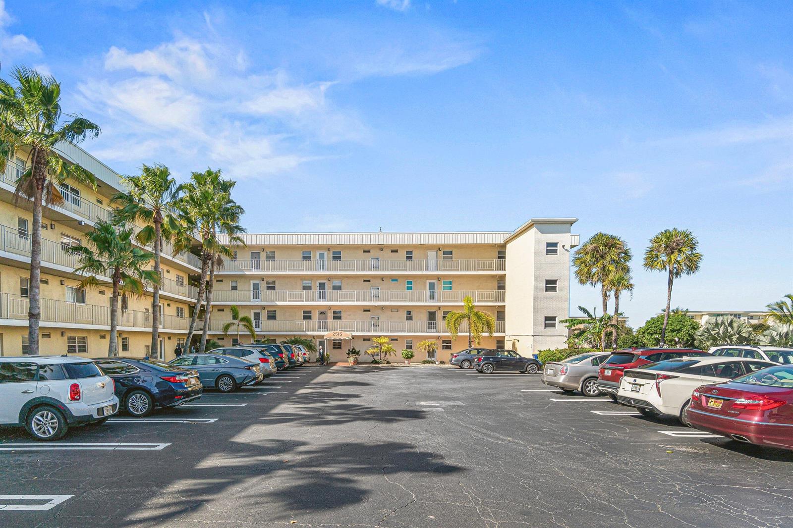 A multi-story apartment building with a parking lot in the foreground and palm trees — 2515 NE 1st Court # 4100, Boynton Beach FL 33435, BOYNTON BEACH, FL