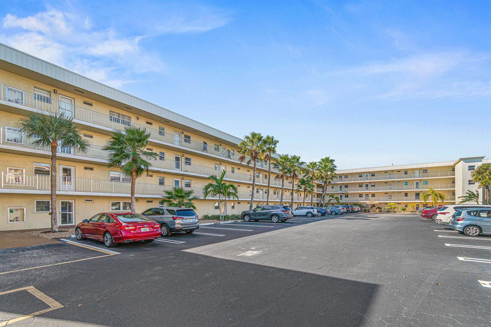 A multi-story apartment building with balconies and a parking lot in front — 2515 NE 1st Court # 4100, Boynton Beach FL 33435, BOYNTON BEACH, FL