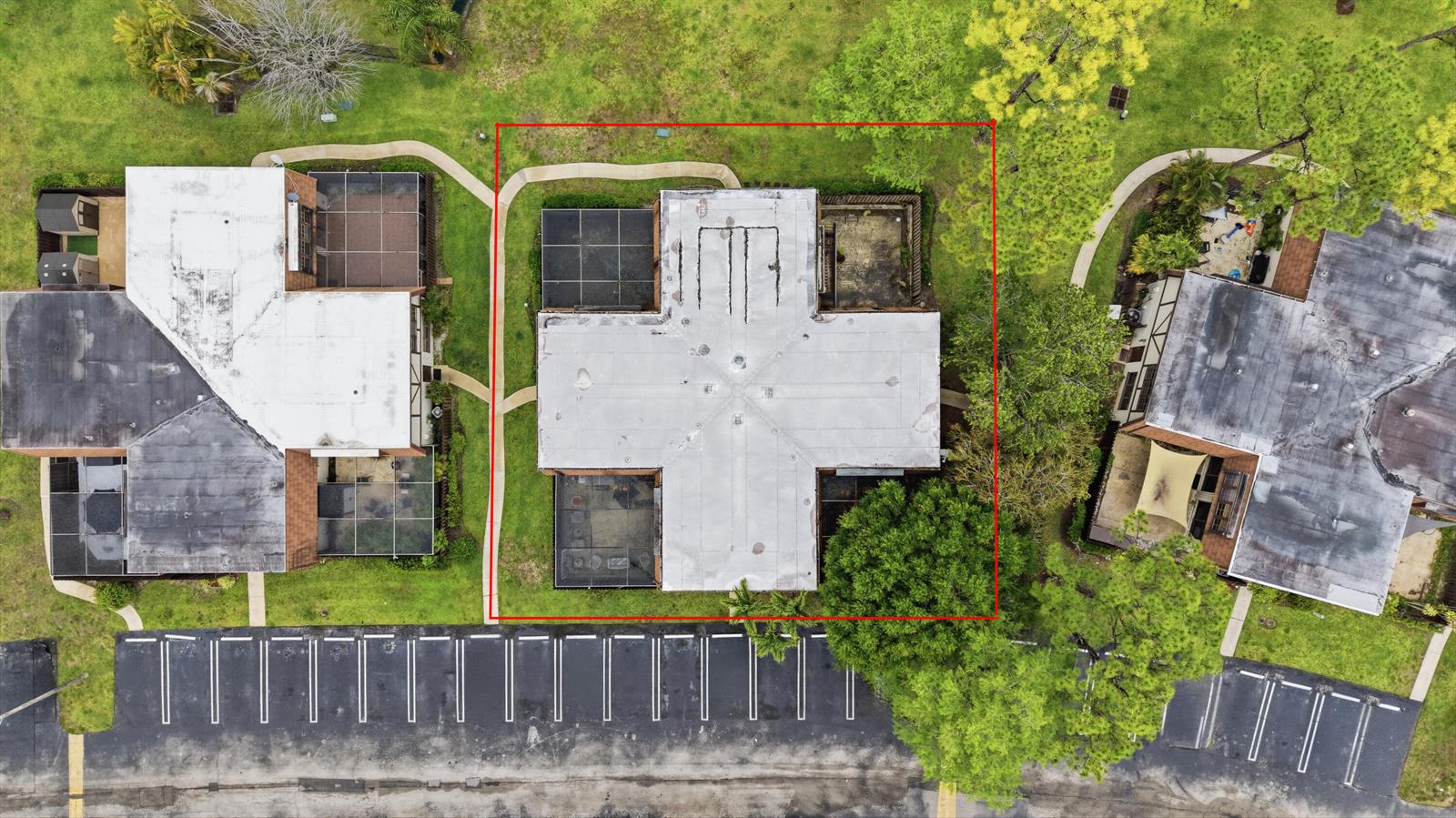 An aerial view shows a cross-shaped building with a flat roof surrounded by landscaping — 105 Weybridge Circle # A, Royal Palm Beach FL 33411, ROYAL PALM BEACH, FL