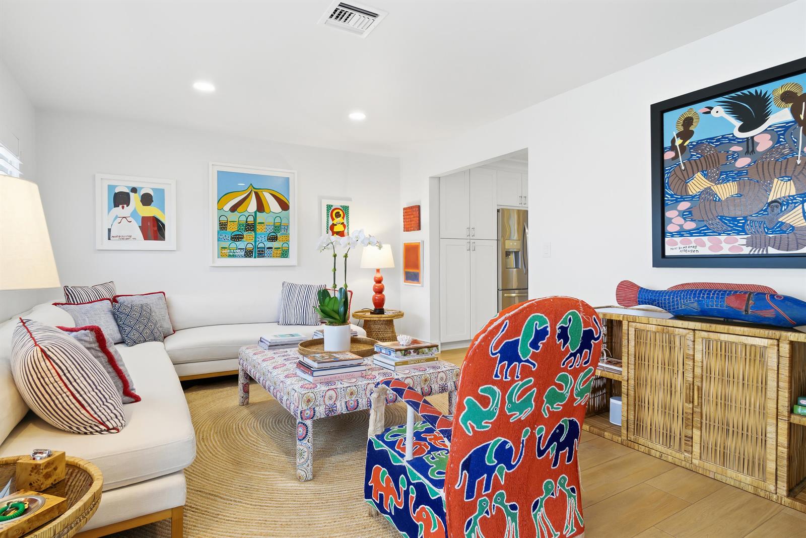 A living room features a white sofa, patterned armchair, coffee table, and colorful wall art — 251 Gregory Place, West Palm Beach FL 33405, WEST PALM BEACH, FL
