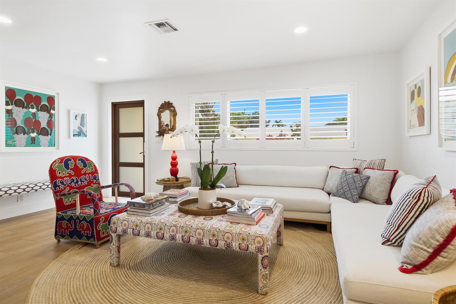 A living room features a white sectional sofa, patterned armchair, and a central upholstered ottoman — 251 Gregory Place, West Palm Beach FL 33405, WEST PALM BEACH, FL