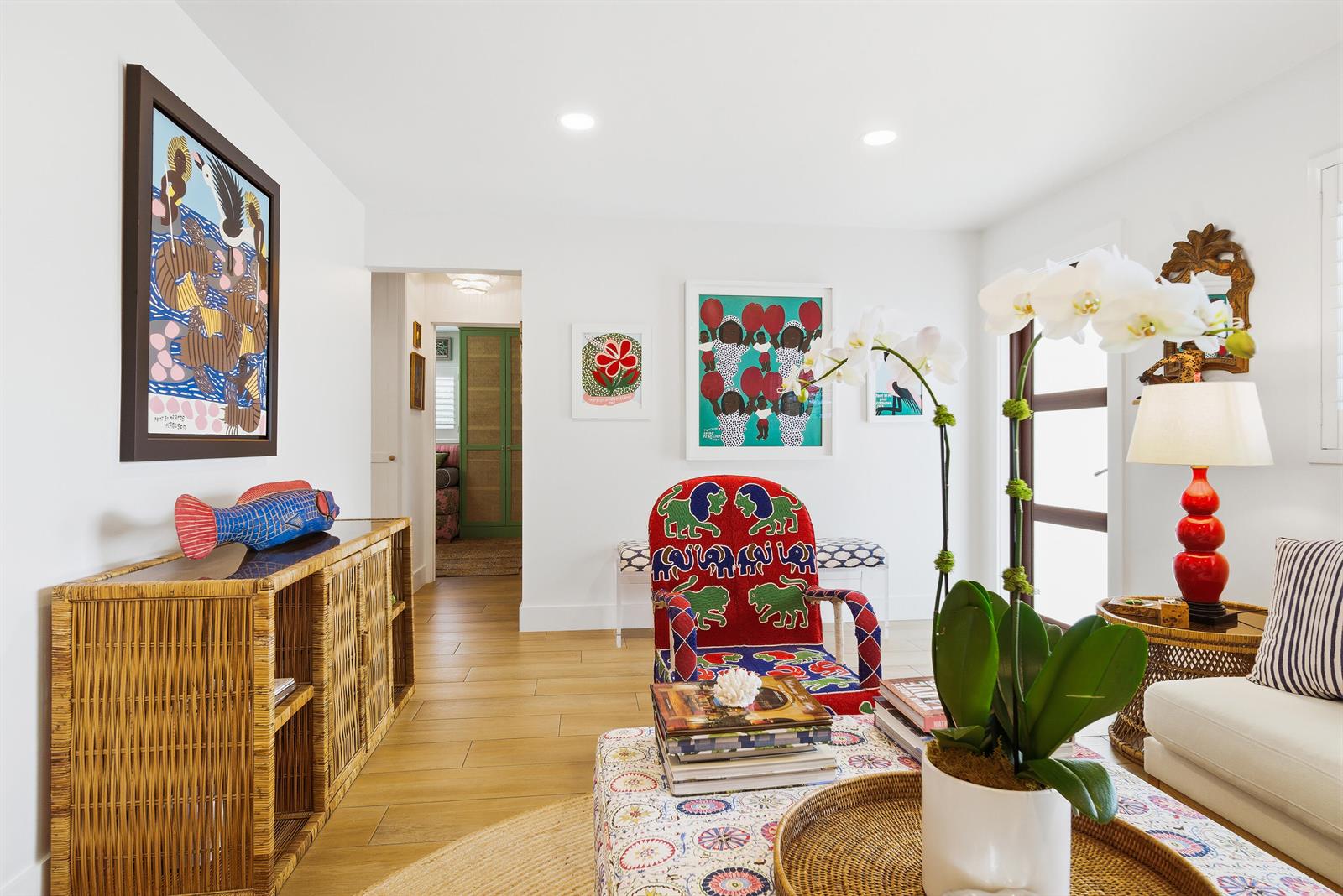 A living room features a rattan console, a patterned armchair, and white walls with artwork — 251 Gregory Place, West Palm Beach FL 33405, WEST PALM BEACH, FL