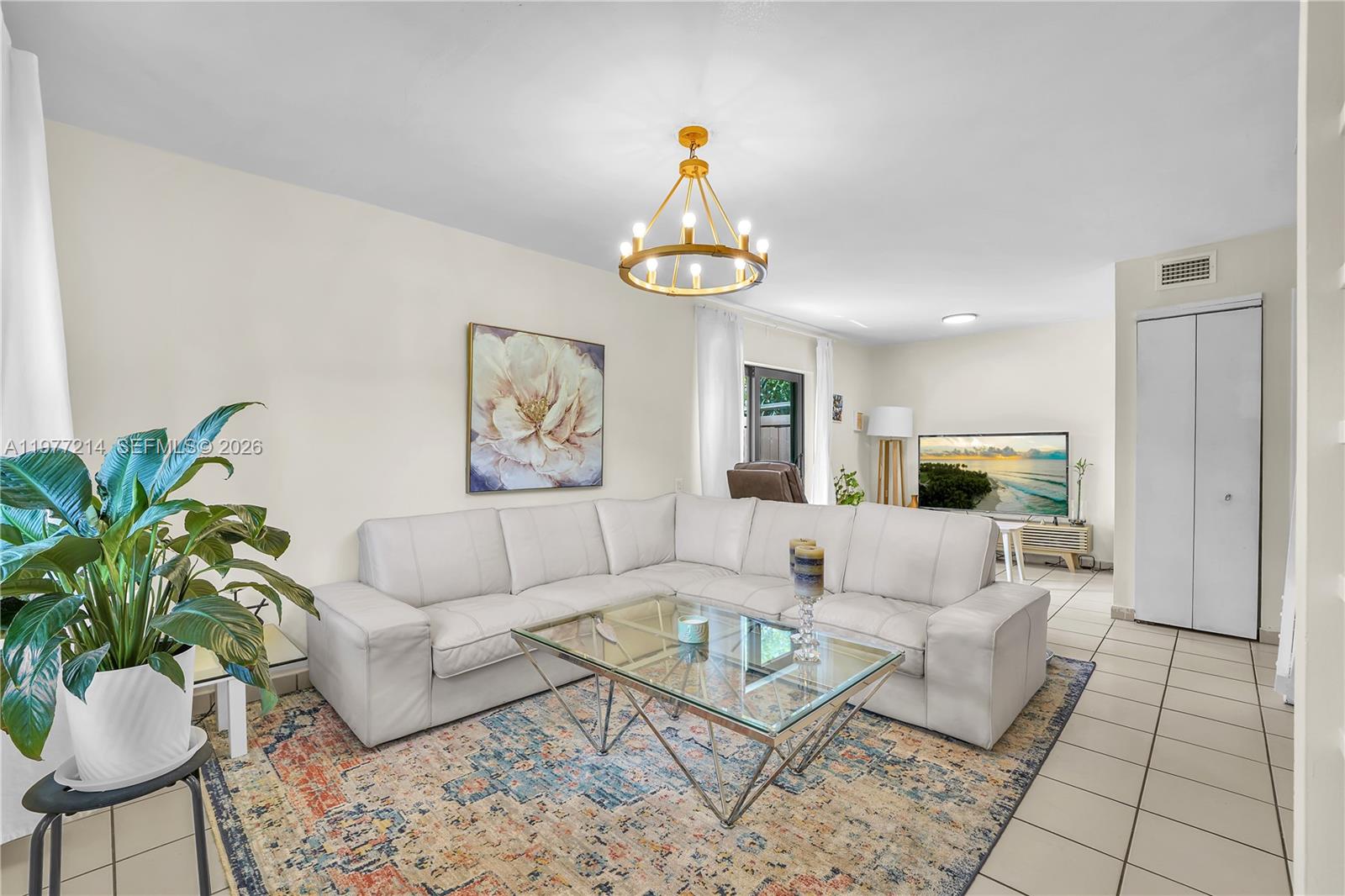 A living room features a white sectional sofa, a glass coffee table, and a chandelier — 6639 SW 116th Pl # 1, Miami FL 33173, MIAMI, FL