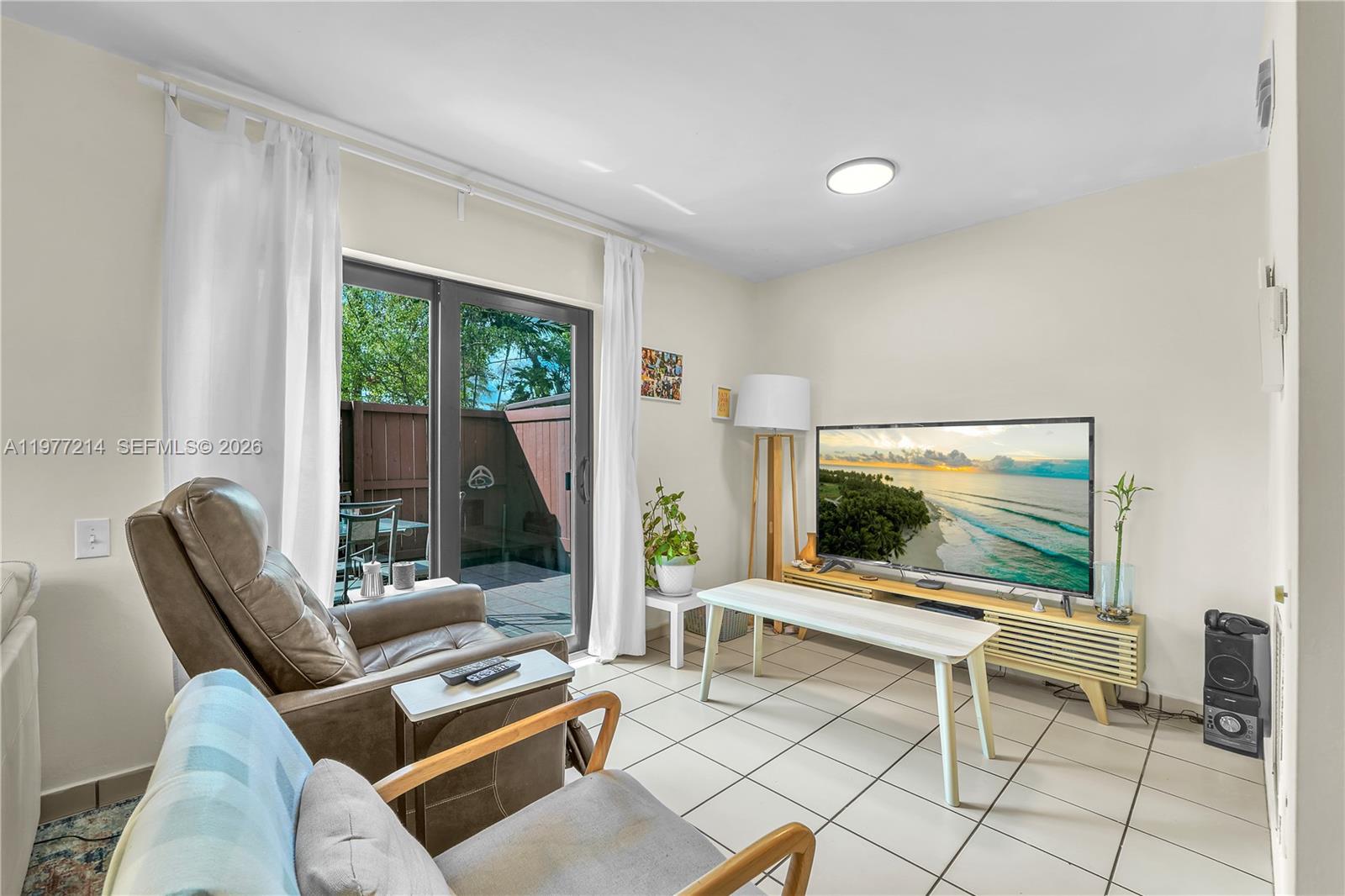 A living room features tile floors, a television on a stand, and sliding glass doors — 6639 SW 116th Pl # 1, Miami FL 33173, MIAMI, FL