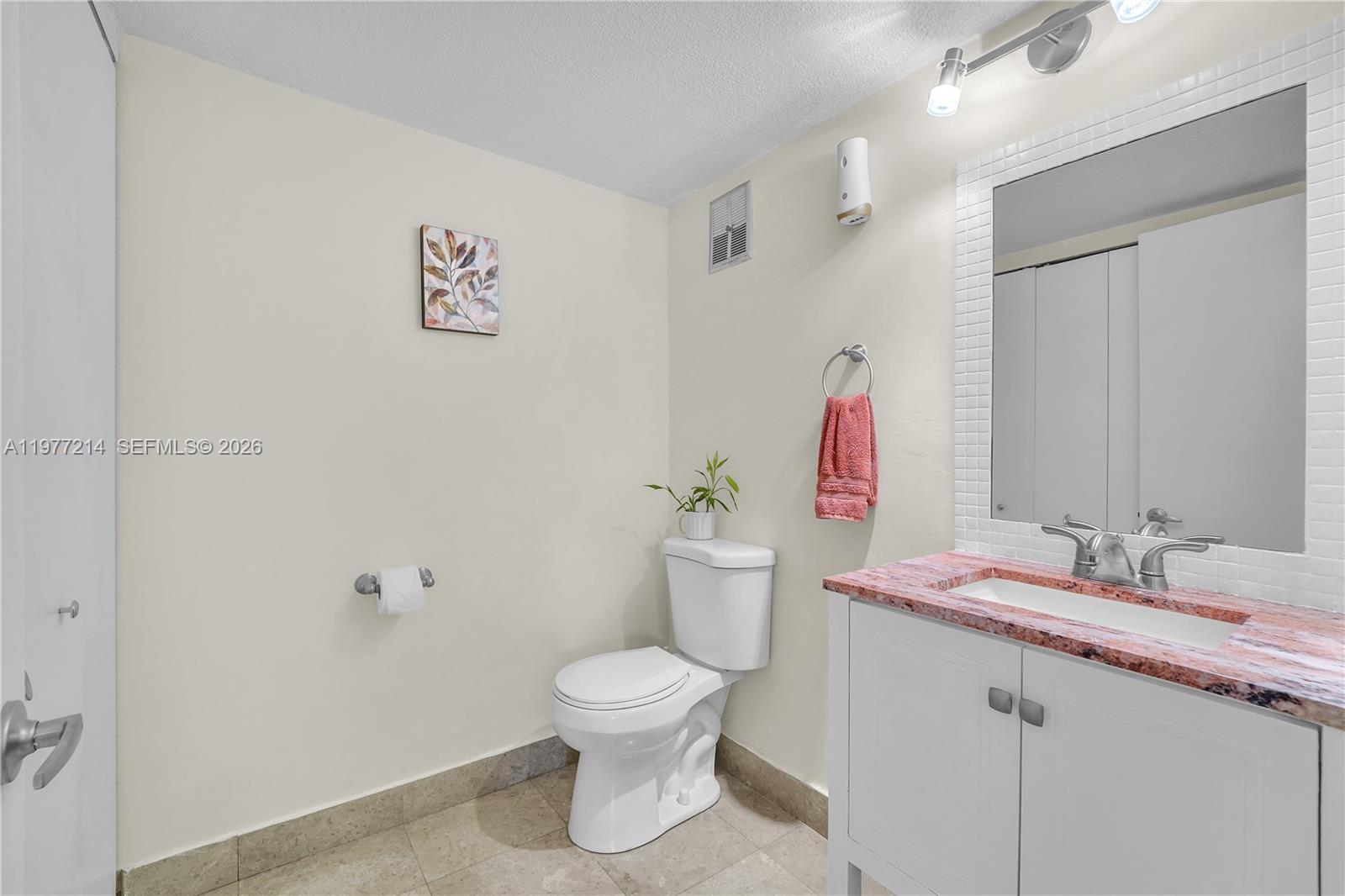 A bathroom features a white vanity with a pink granite countertop and a toilet — 6639 SW 116th Pl # 1, Miami FL 33173, MIAMI, FL