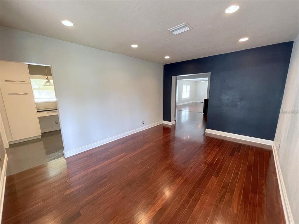An empty room with dark hardwood floors, light gray walls, and a glass-paneled exterior door — 3903 W CORONA STREET, TAMPA, FL