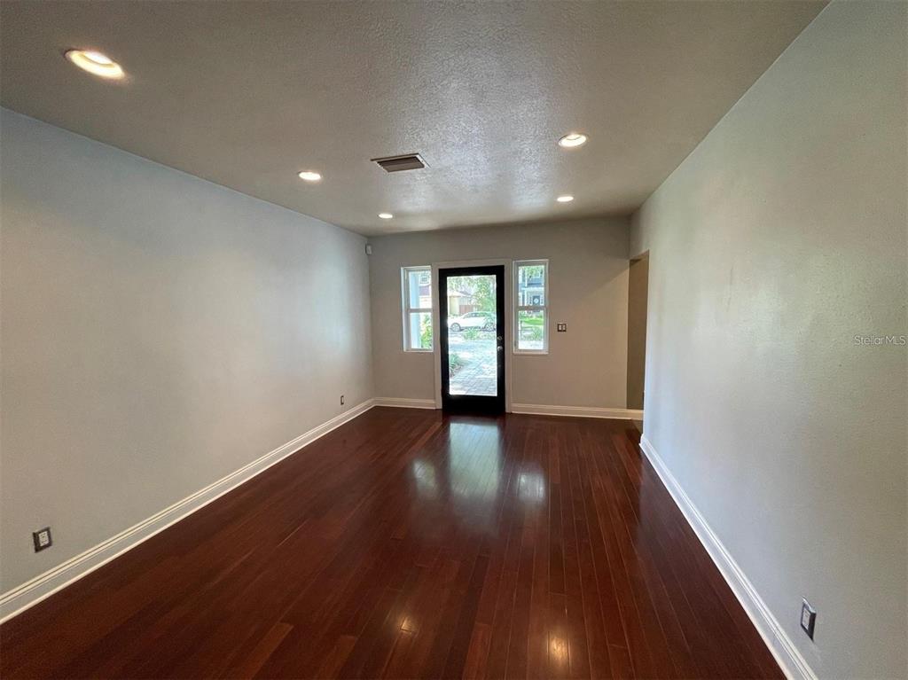 An empty room with dark hardwood floors, gray walls, and white plantation shutters — 3903 W CORONA STREET, TAMPA, FL