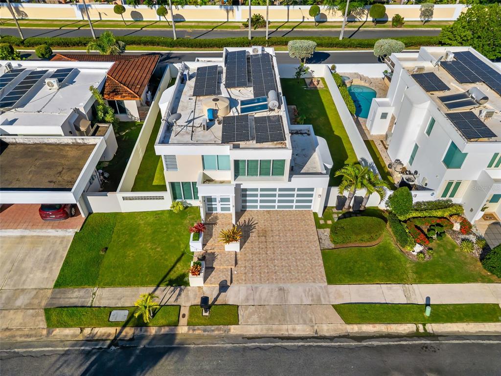 An aerial view shows a two-story house with solar panels on the flat roof — D-44 CALLE AMATISTA, DORADO, PR