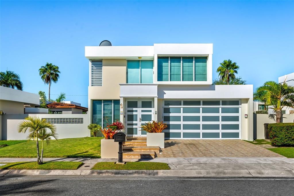 A modern two-story house with a white facade, glass garage door, and front landscaping — D-44 CALLE AMATISTA, DORADO, PR