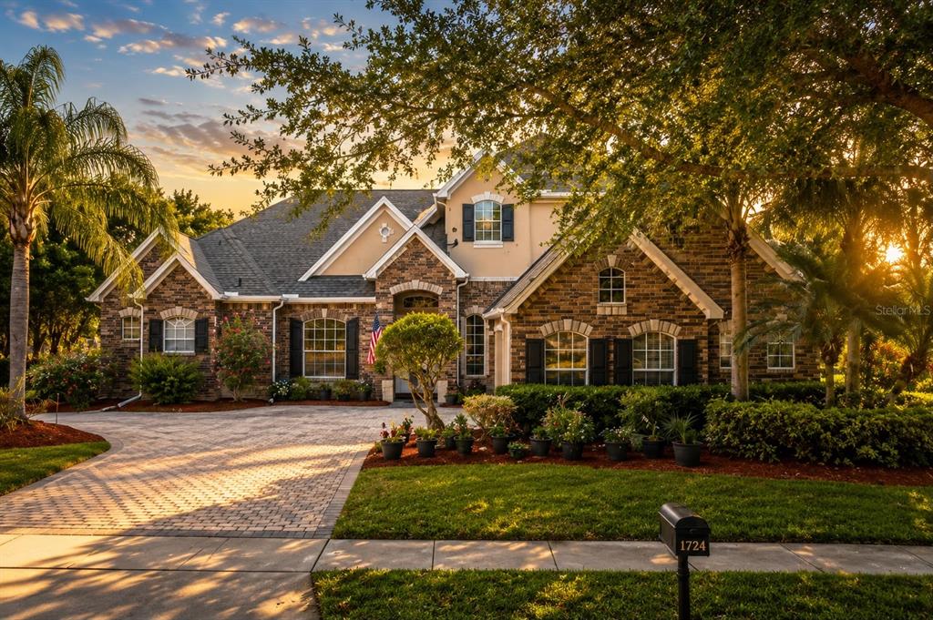A two-story brick house with a paved driveway, manicured landscaping, and a mailbox in front — 1724 BRIDGETS COURT, KISSIMMEE, FL