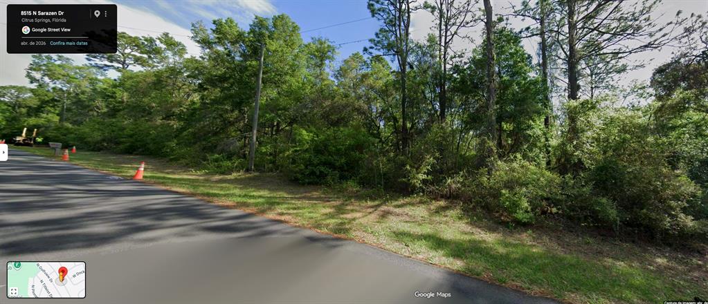 A vacant, wooded lot sits along a paved road with orange traffic cones nearby — 8515 N SARAZEN DRIVE, CITRUS SPRINGS, FL