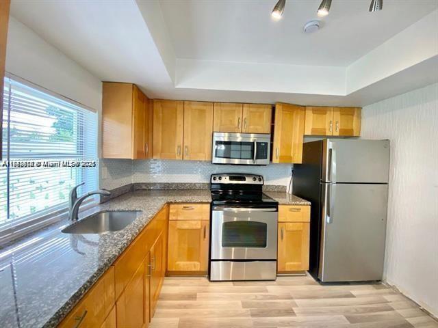 A kitchen features light wood cabinets, granite countertops, stainless steel appliances, and a window — 6521 NW 21st St, Sunrise FL 33313, SUNRISE, FL