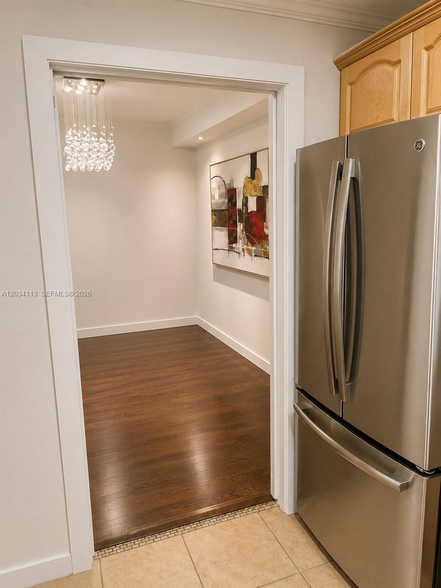 A doorway leads from a tiled kitchen into a room with dark wood flooring — 180 NE 12th Ave # 16E, Hallandale Beach FL 33009, HALLANDALE BEACH, FL