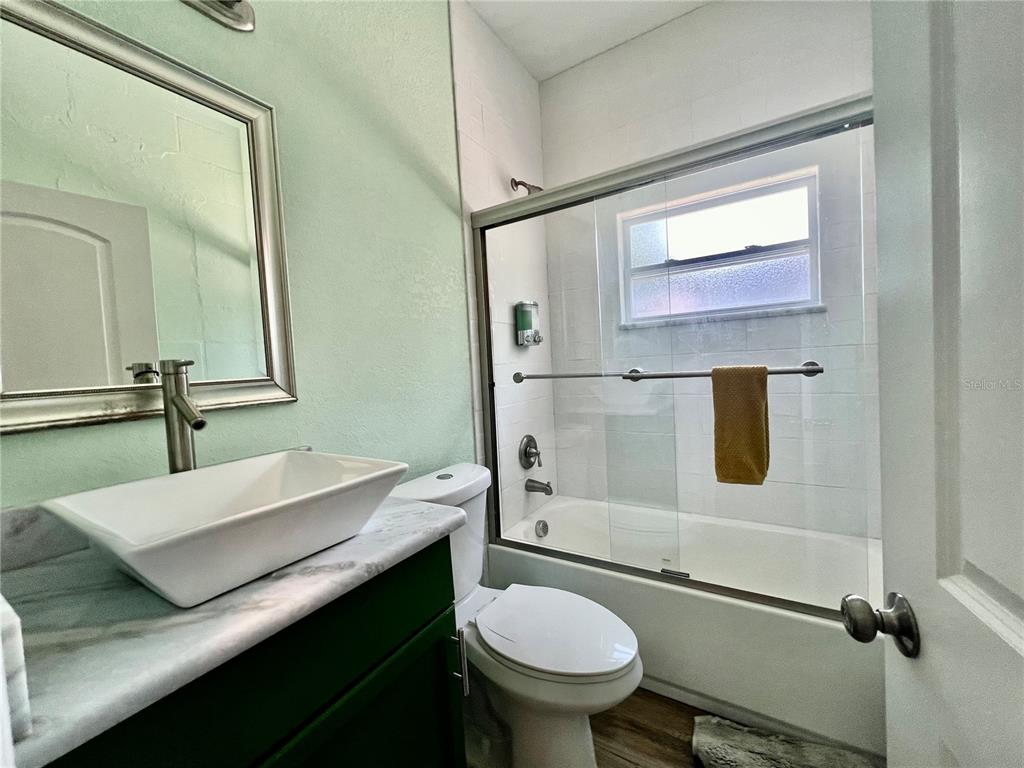A bathroom features a vessel sink, a toilet, and a shower-tub combination with glass doors — 821 MULBERRY STREET UNIT D, MAITLAND, FL