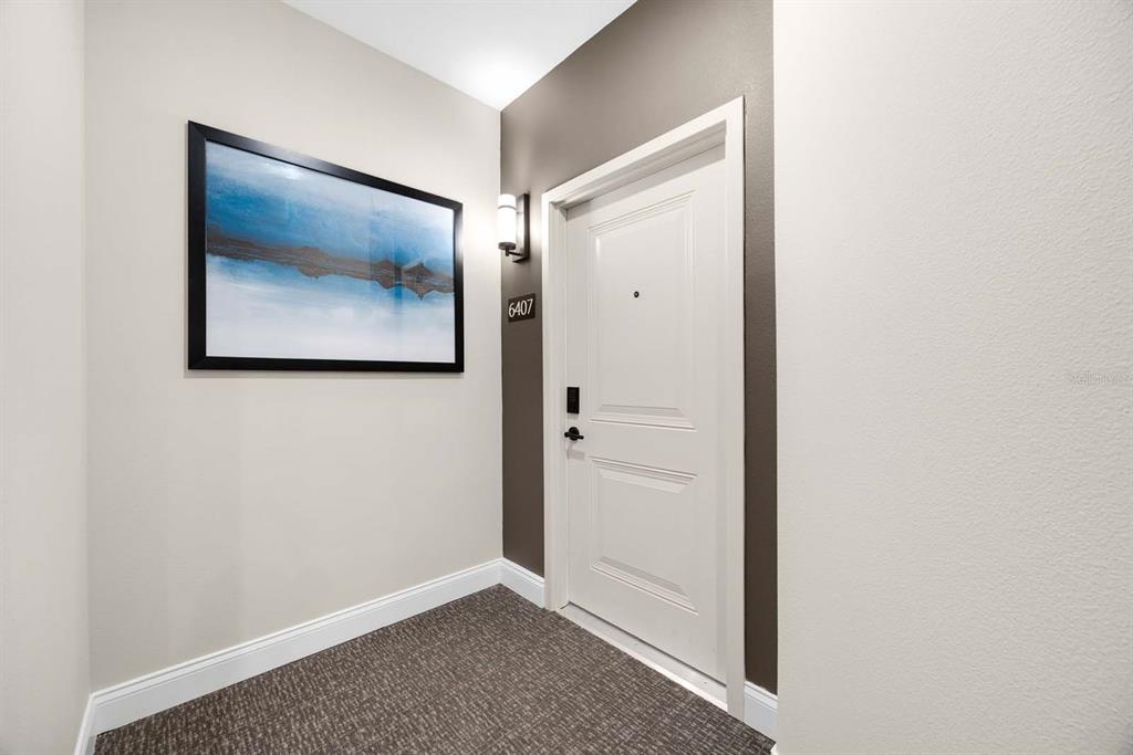 A white door with the number 6407 is set against a dark accent wall — 7557 LAUREATE BOULEVARD UNIT 6407, ORLANDO, FL