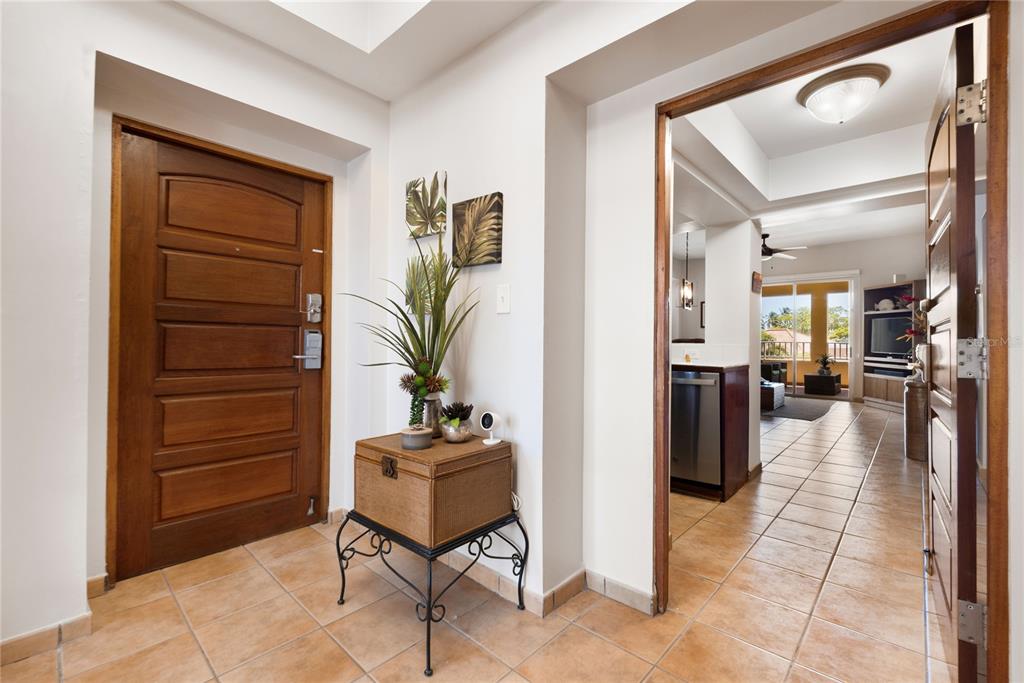 An entryway with a wooden door and a wicker chest leads into a tiled living area — . CANDELERO DRIVE UNIT A303, HUMACAO, PR