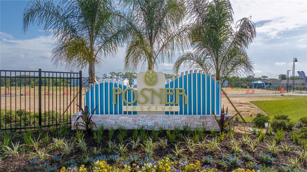 A stone and blue-slatted monument sign for Posner Reserve stands before a landscaped garden — 137 PEGASUS STREET, DAVENPORT, FL