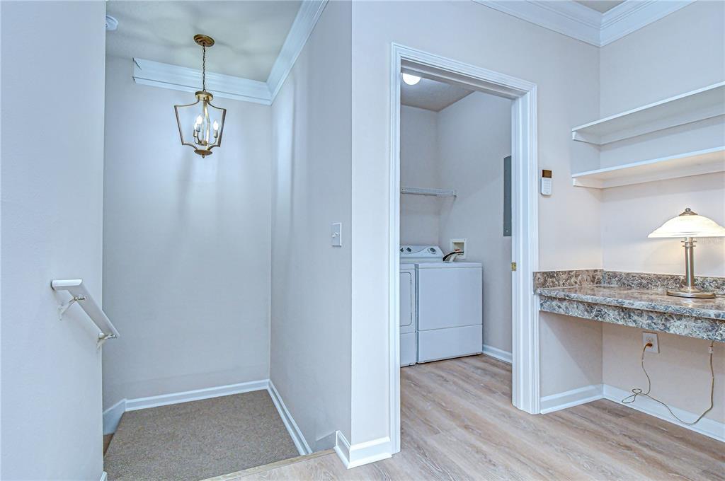 A laundry room with a desk area and a staircase leading down to a landing — 10409 VILLA VIEW CIRCLE UNIT 10409, TAMPA, FL