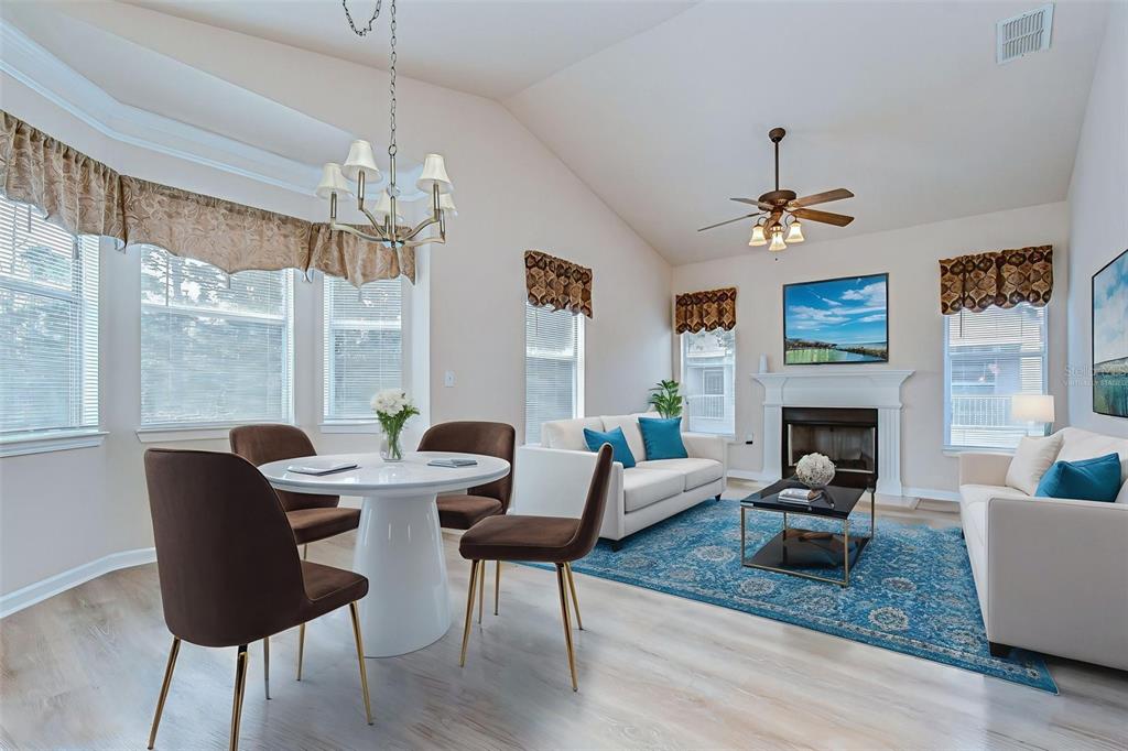A bright living and dining area features a white table, sofas, and a fireplace — 10409 VILLA VIEW CIRCLE UNIT 10409, TAMPA, FL