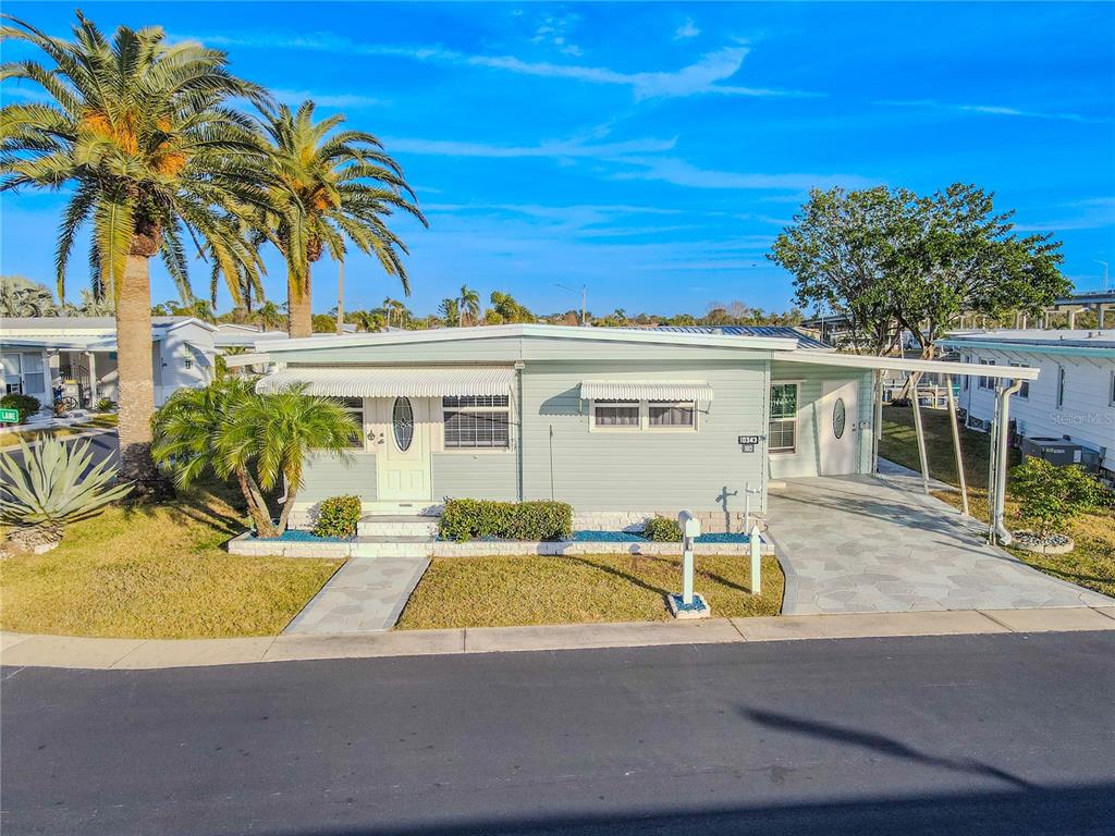 An aerial view of a mobile home community featuring a canal and palm trees — 10343 MAGNOLIA LANE UNIT 180, LARGO, FL