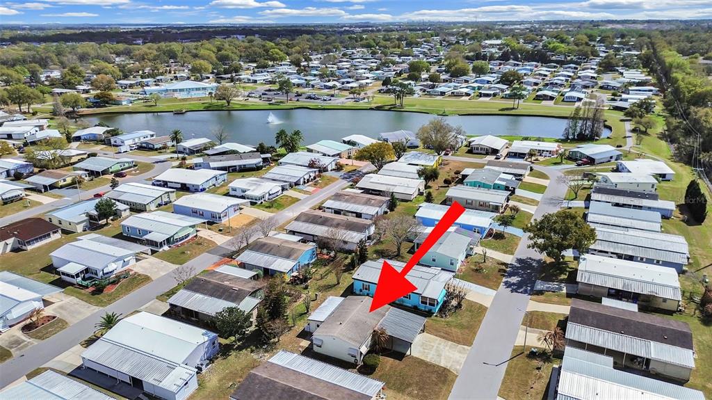 An aerial view shows a manufactured home community with a lake and a marked house — 4969 DEERWOOD DR, LAKELAND, FL