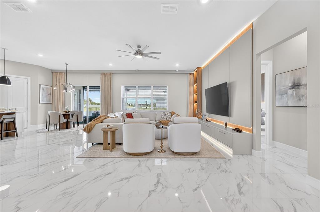 A modern open-concept living room features white marble floors, a large sectional, and accent lighting — 13207 PANAMA BEACH COURT, ORLANDO, FL