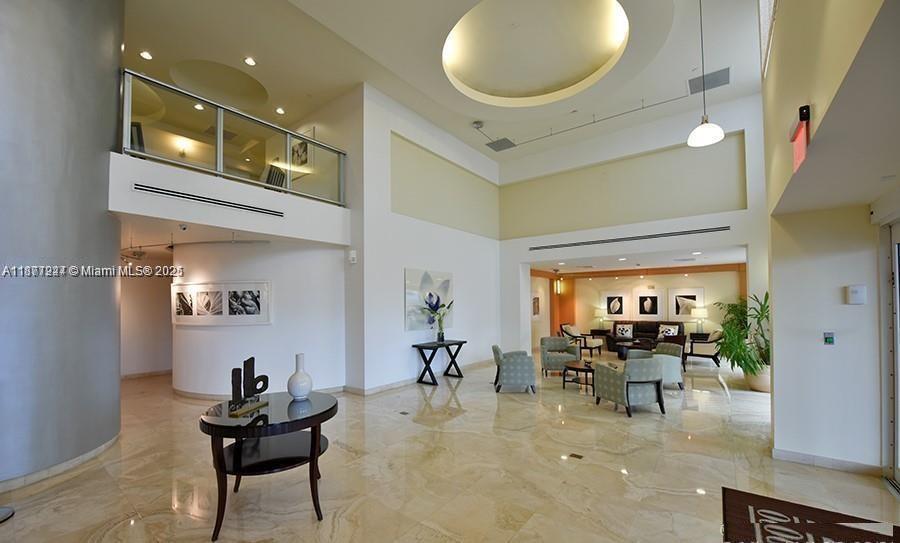 A spacious lobby features high ceilings, marble floors, a mezzanine level, and comfortable seating areas — 2080 S Ocean Dr # 1507, Hallandale Beach FL 33009, HALLANDALE BEACH, FL