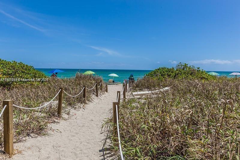A sandy path leads through dunes toward the ocean under a clear blue sky — 2080 S Ocean Dr # 1507, Hallandale Beach FL 33009, HALLANDALE BEACH, FL