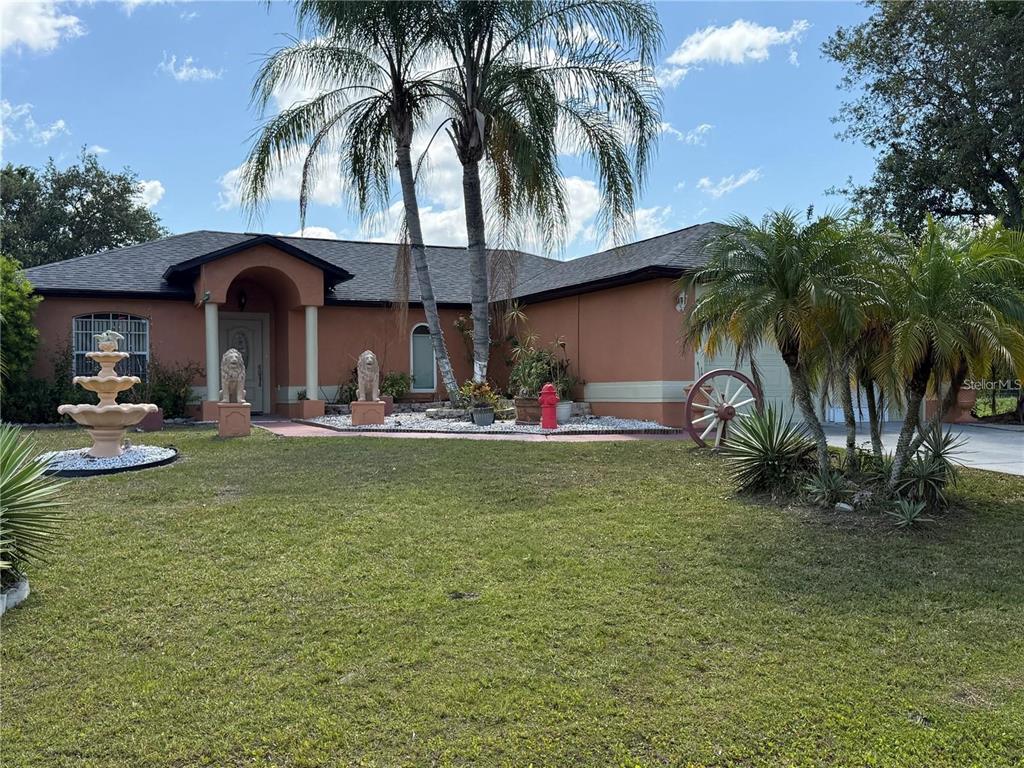 A single-story house with a terracotta exterior, a front fountain, and two palm trees — 3900 OAK POINTE BOULEVARD, KISSIMMEE, FL
