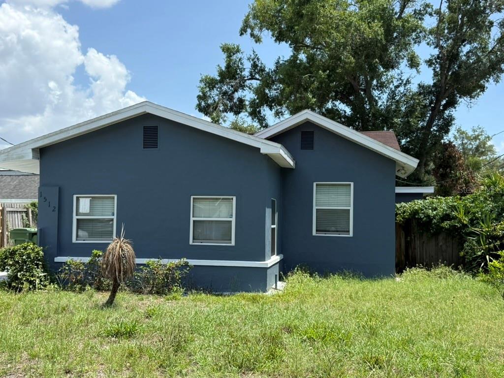 A blue single-story house with a white trim and a grassy front yard — 1512 W KIRBY STREET, TAMPA, FL