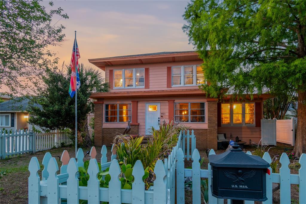 A two-story house with peach siding, brick accents, and two flags on a pole — 4621 9TH AVENUE N, ST PETERSBURG, FL