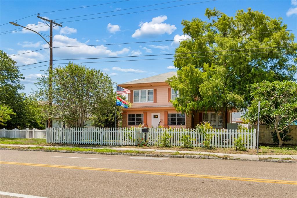An aerial view shows a two-story pink house with a white fence and large trees — 4621 9TH AVENUE N, ST PETERSBURG, FL
